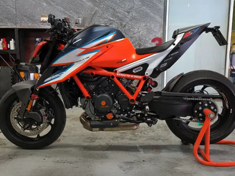 Custom vinyl wrap on KTM motorcycle, finished in orange and black at our Kidderminster workshop